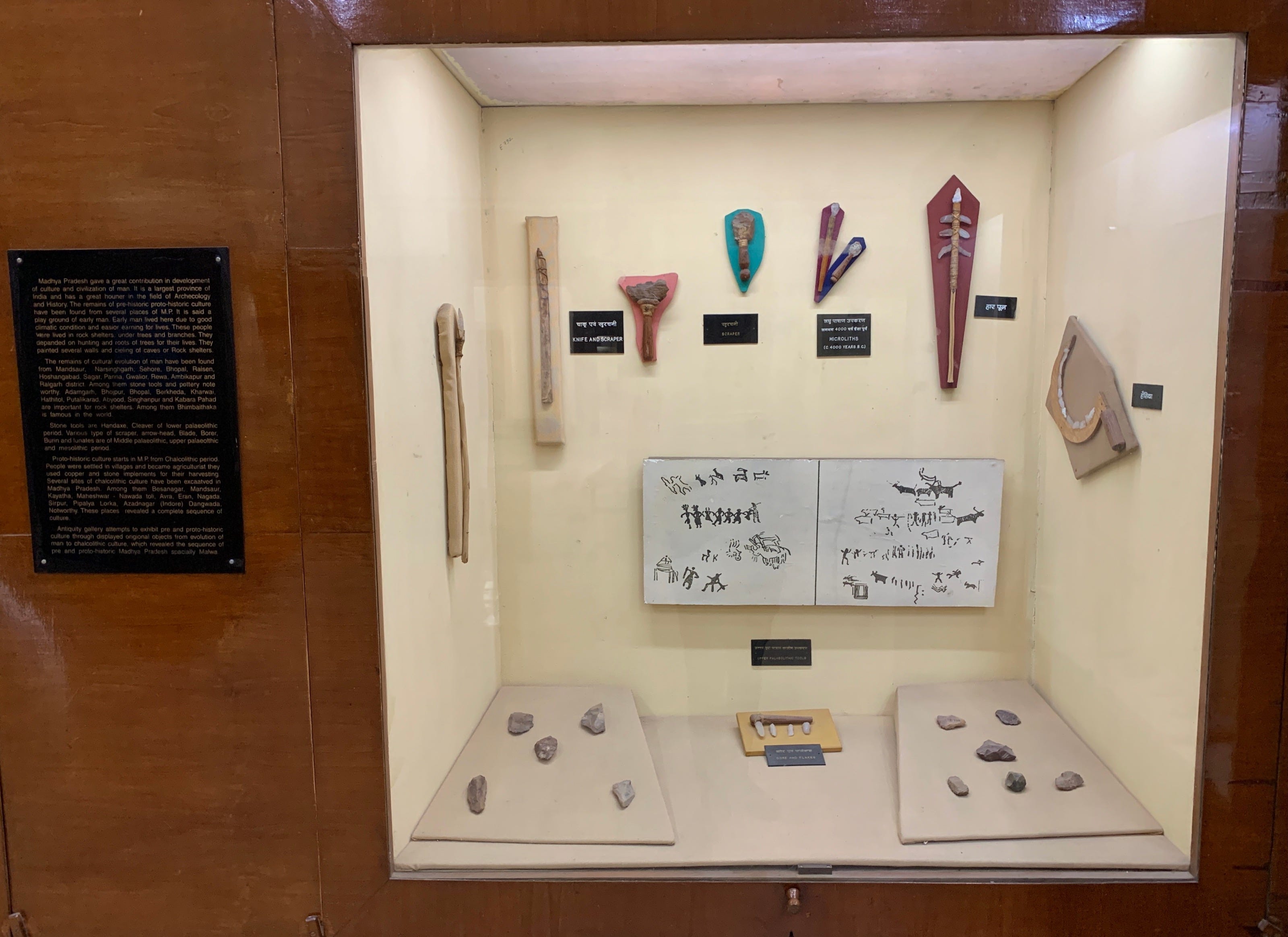 A museum glassed display of an Upper Paleolithic knife, scraper, microliths, harpoon, flakes, and more.