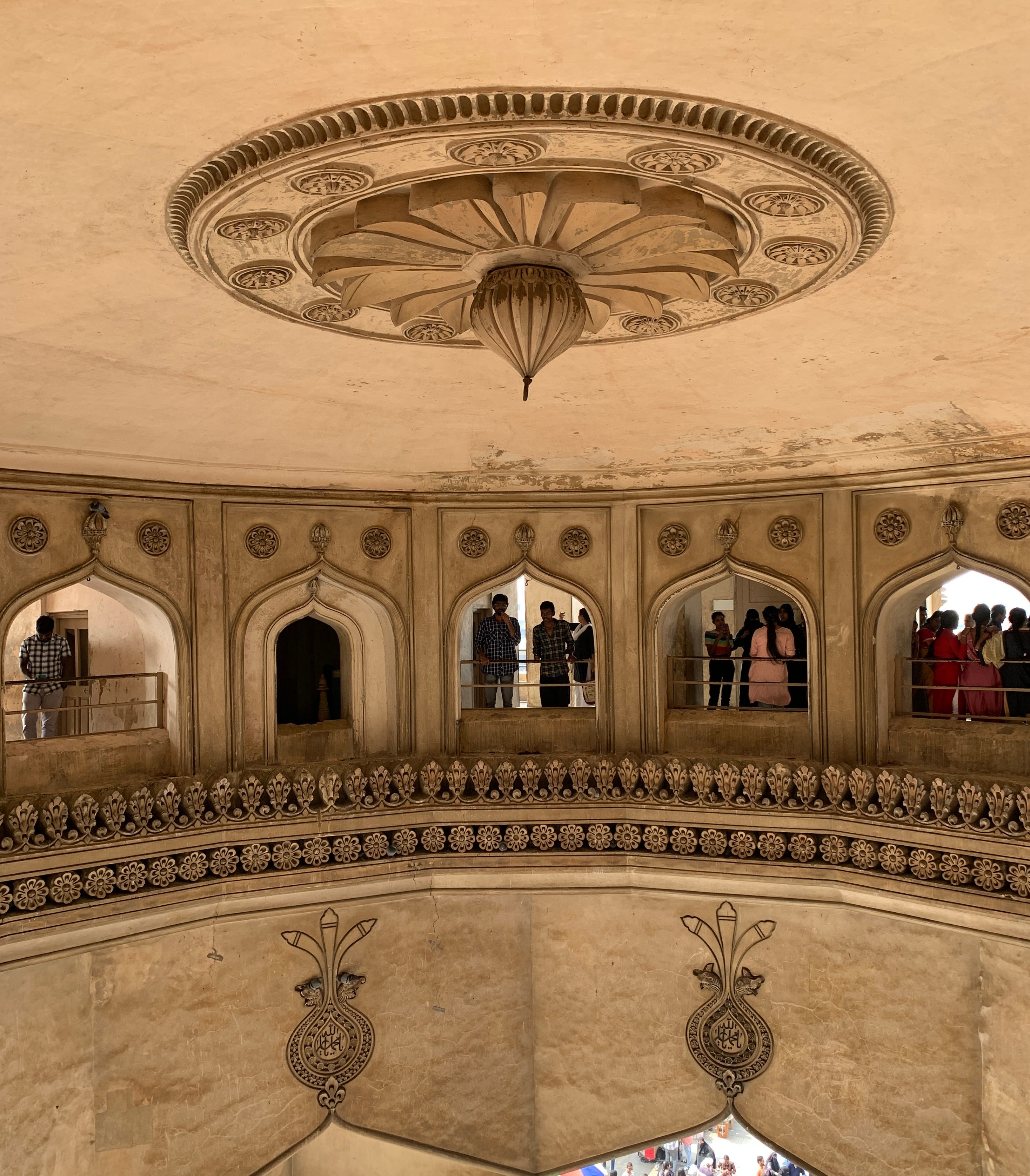 A circular section inside Charminar with windows on all sides, and an ornate ceiling.